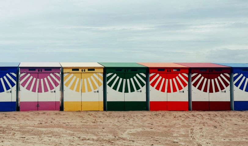 Des cabines de plage colorées, numérotées de 65 à 69.