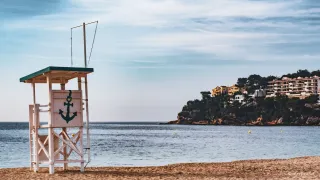 Une tour en bois sur une plage. Elle est utilisée par les personnes en charge de la surveillance. Une ancre est peinte dessus.
