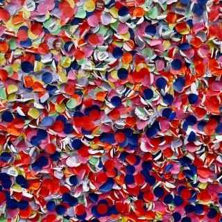 Plein de gros confettis de toutes les couleurs (un peu passées). Certains confettis ont du texte inscrit dessus: « Visite guidée »