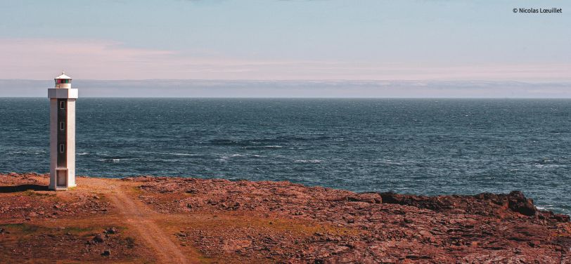 Un phare sur l'extrême gauche de la photo. Derrière, la mer.