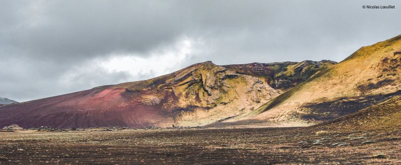 Des montagnes aux nuances vertes et rouges.