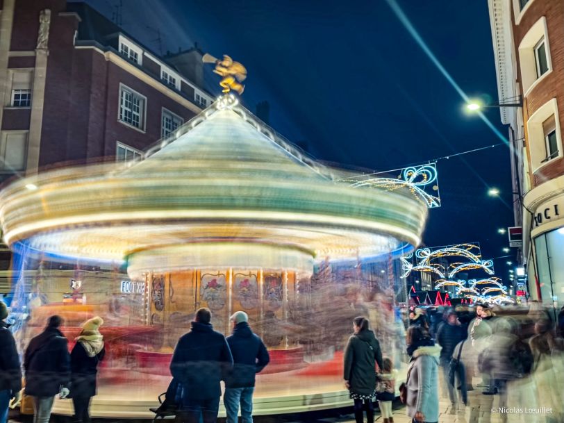Un carrousel dans la nuit avec un effet de vitesse.